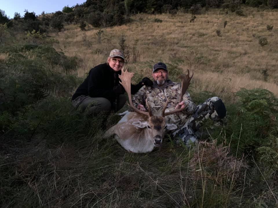 Two hunters celebrating a successful lynx hunt with their guide.